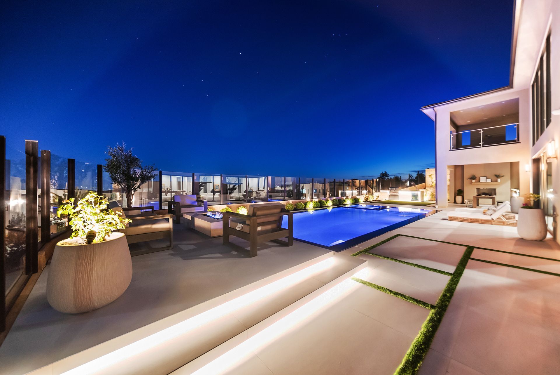 Luxury pool design and construction in Porter Ranch, Los Angeles. Design and build by Westmod. Night time photo of completed custom pool and outdoor living space.