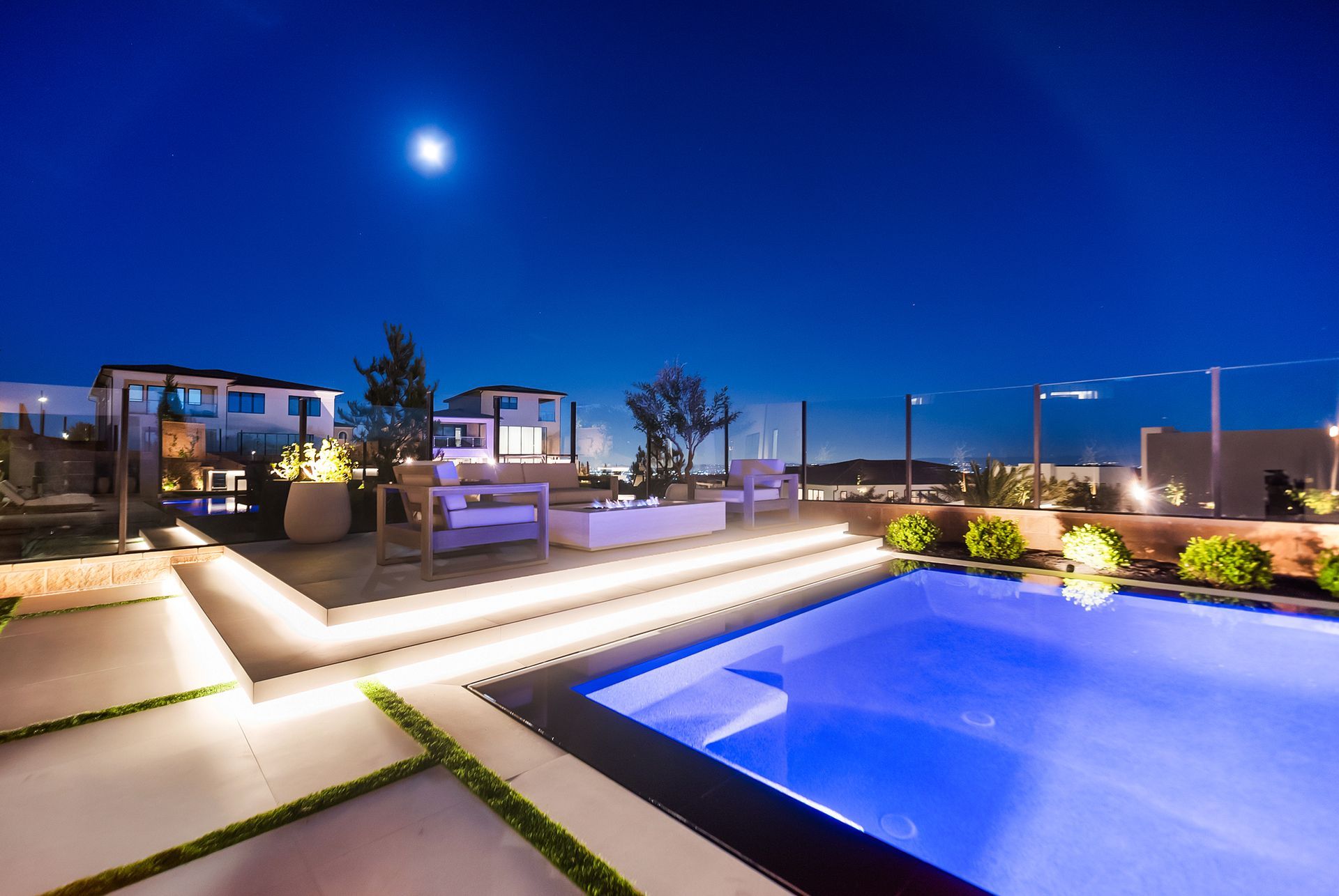 Luxury pool design and construction in Porter Ranch, Los Angeles. Design and build by Westmod. Night time photo of completed custom pool and outdoor living space.