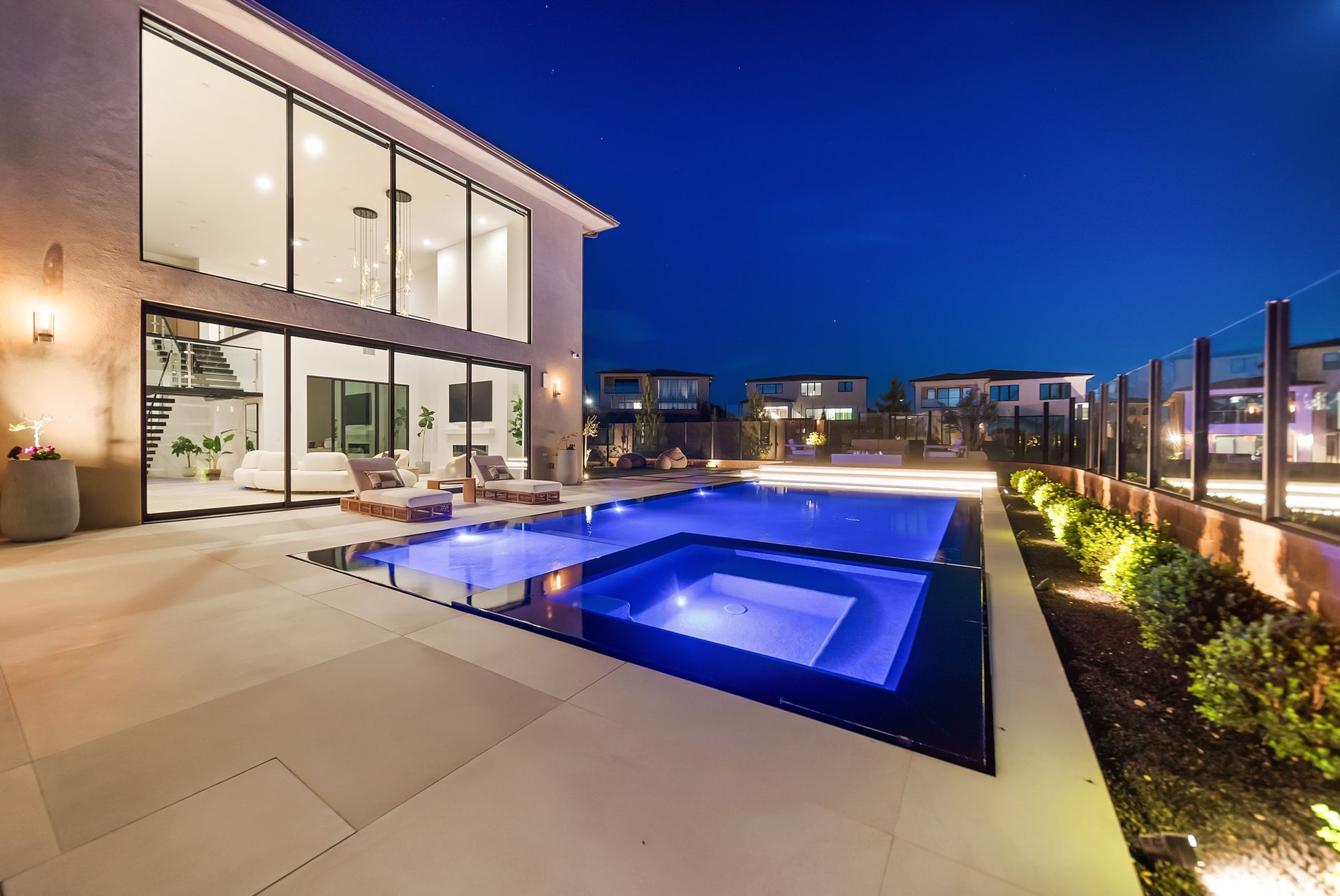 Luxury pool design and construction in Porter Ranch, Los Angeles. Design and build by Westmod. Night time photo of completed custom pool and outdoor living space.
