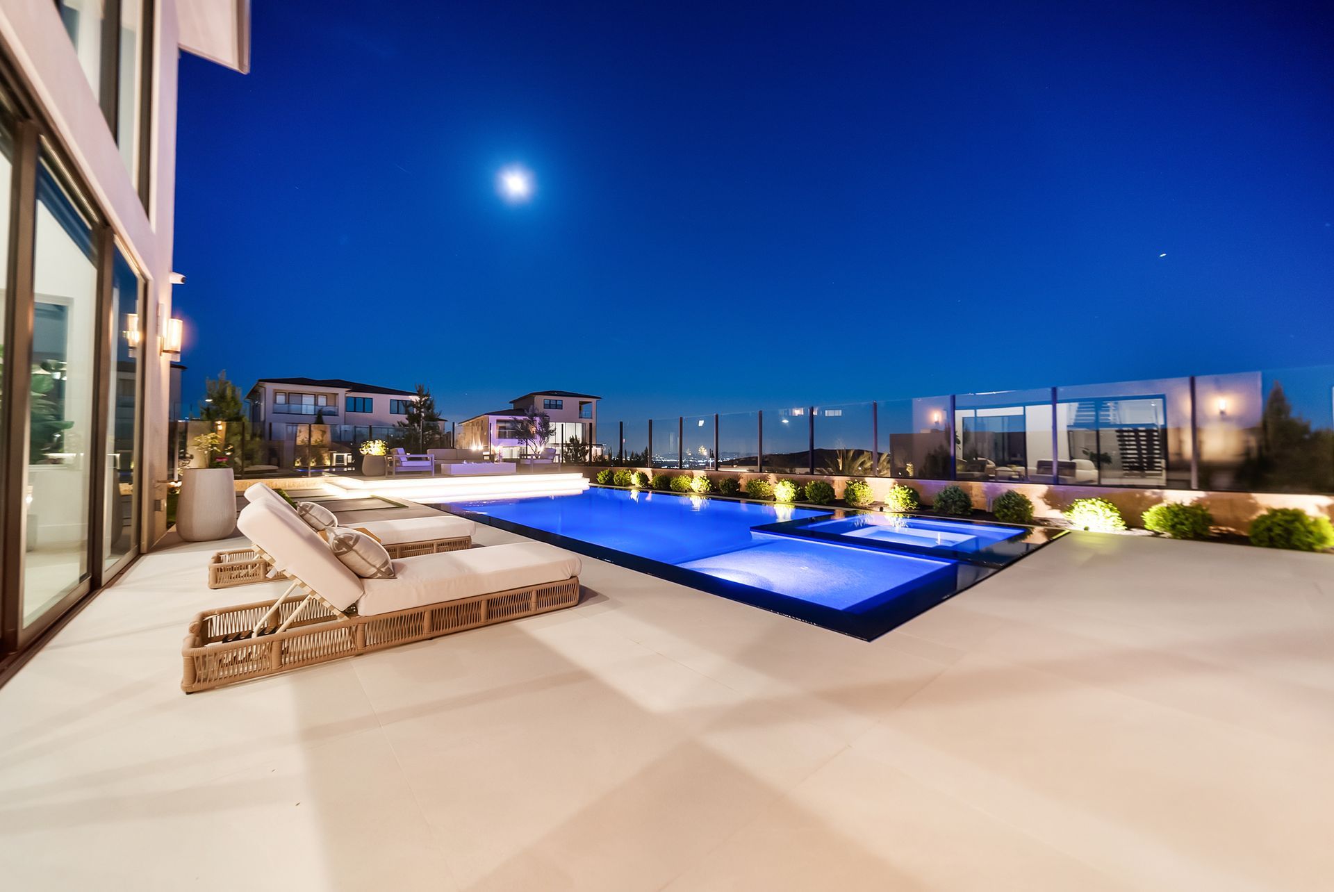 Luxury pool design and construction in Porter Ranch, Los Angeles. Design and build by Westmod. Night time photo of completed custom pool and outdoor living space.