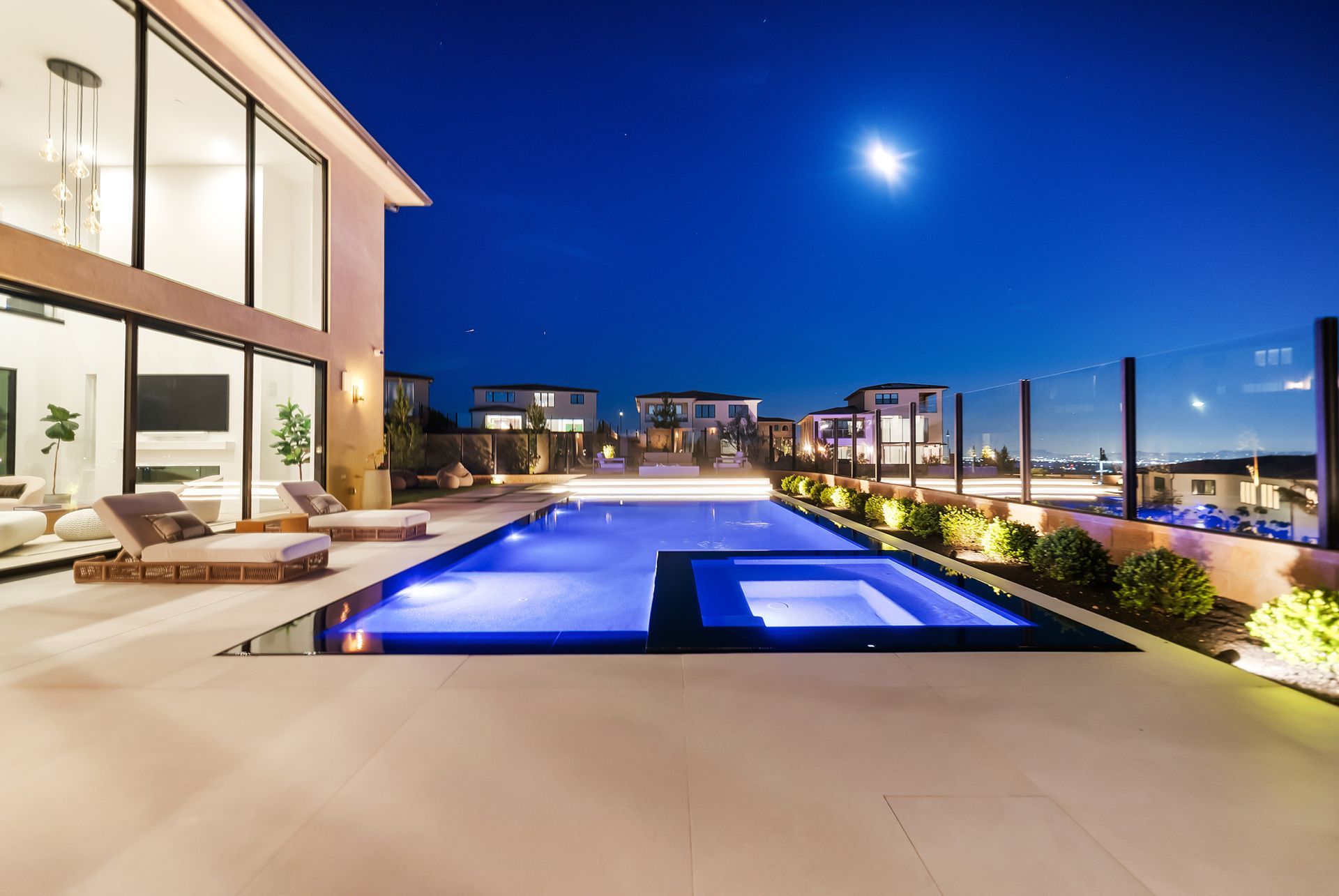 Luxury pool design and construction in Porter Ranch, Los Angeles. Design and build by Westmod. Night time photo of completed custom pool and outdoor living space.