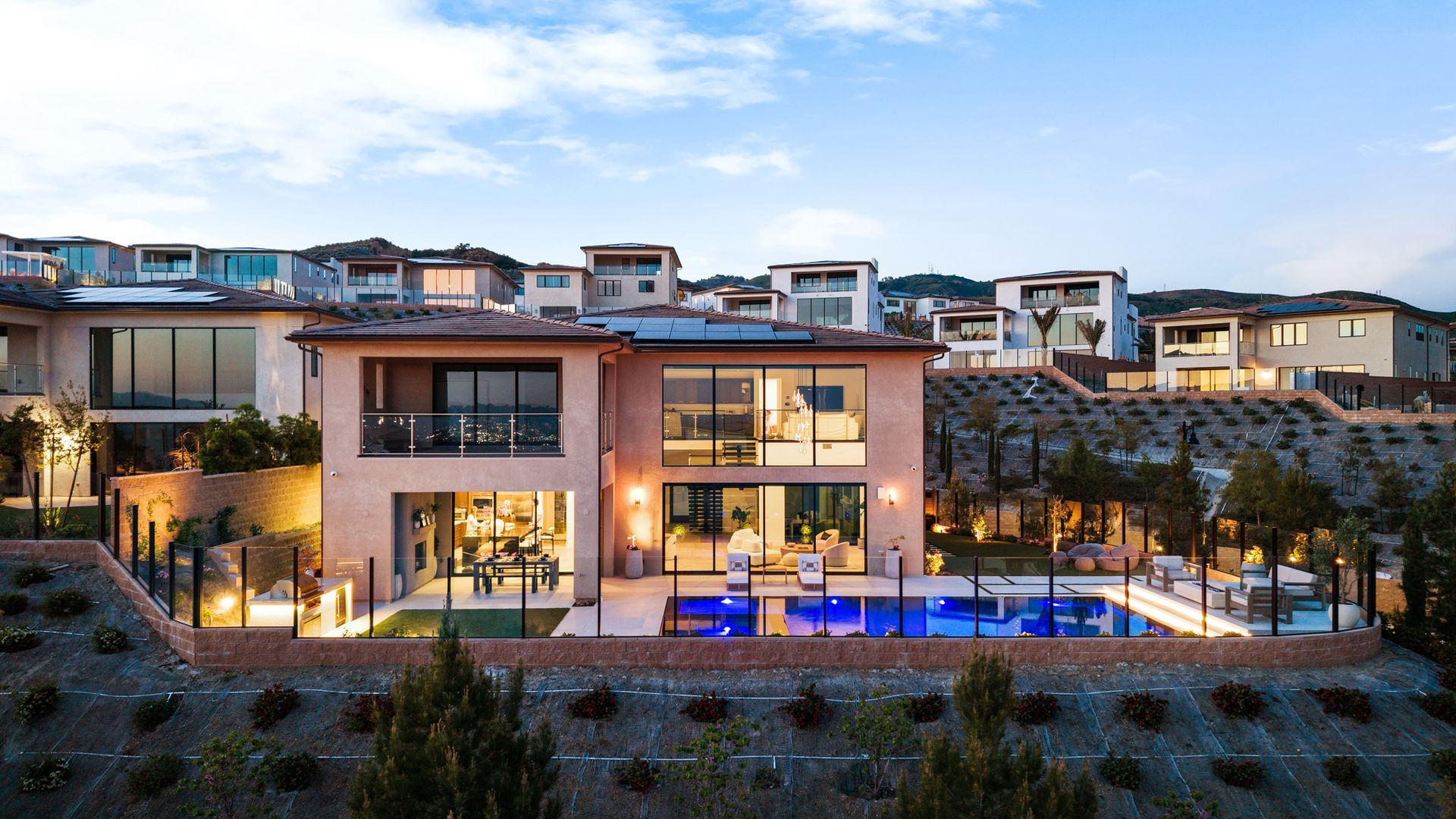 Luxury pool design and construction in Porter Ranch, Los Angeles. Design and build by Westmod. Night time photo of completed custom pool and outdoor living space.