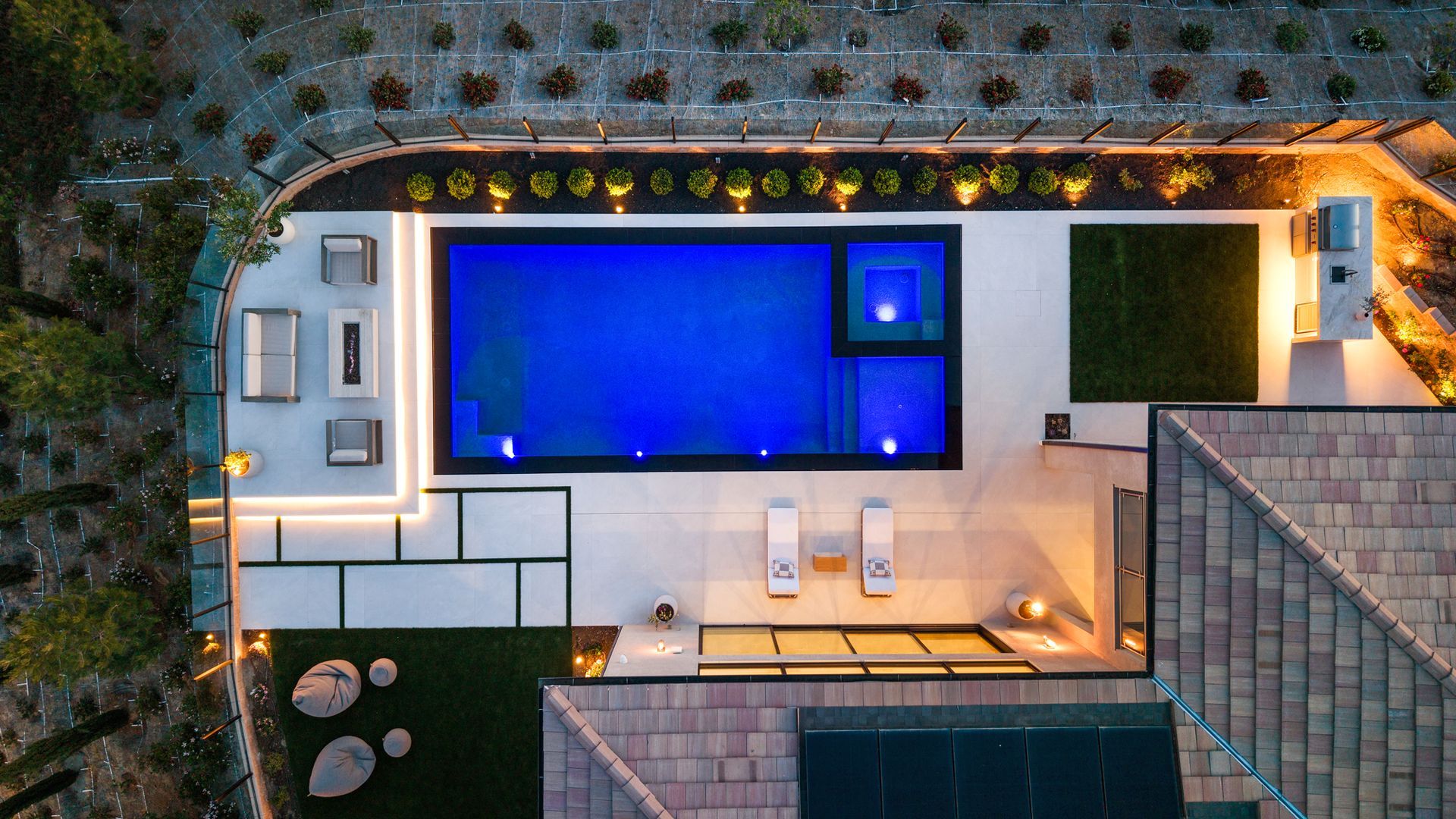 Luxury pool design and construction in Porter Ranch, Los Angeles. Design and build by Westmod. Night time photo of completed custom pool and outdoor living space.