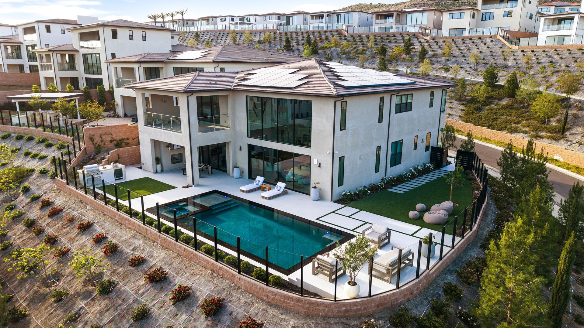 Luxury pool design and construction in Porter Ranch, Los Angeles. Design and build by Westmod. Day time photo of completed custom pool and outdoor living space.