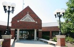 Warren County Courts Building with red brick and three-bulb streetlights in front.