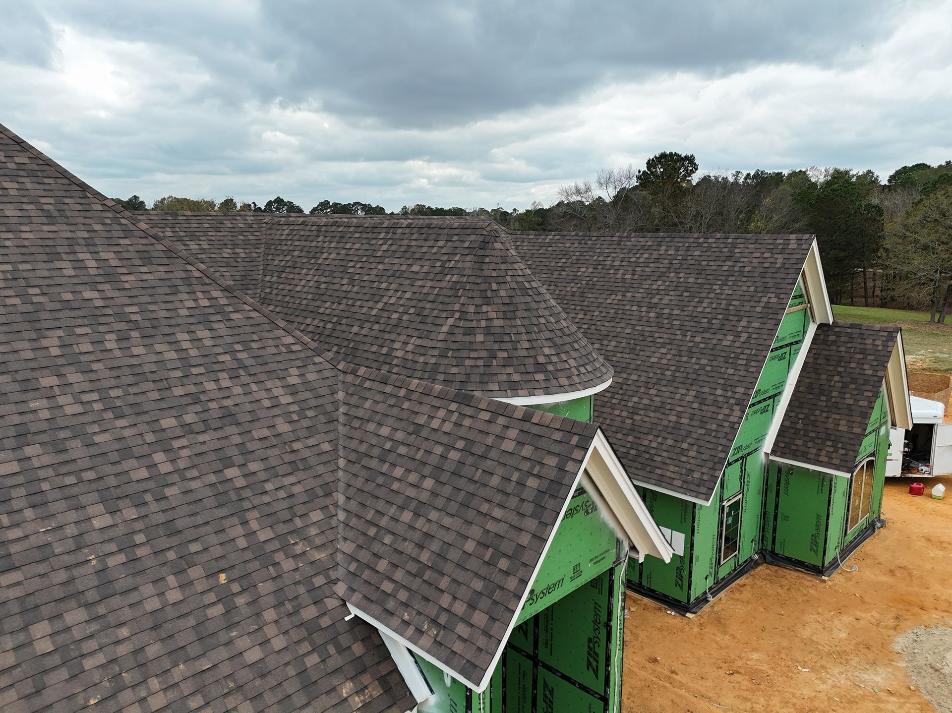 Row of green houses with steep dark shingle roofs viewed from above
