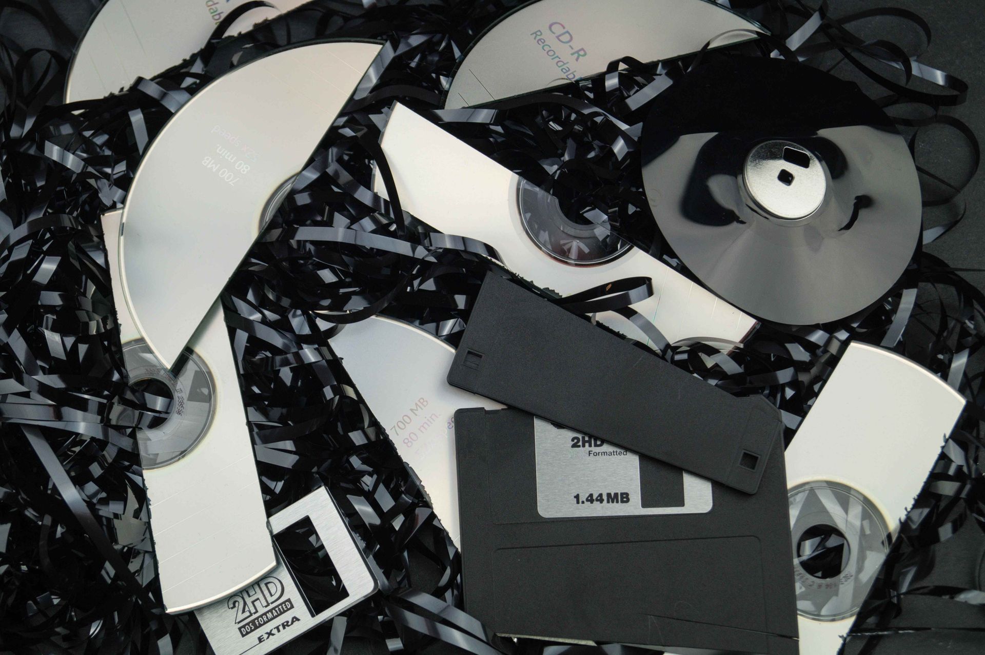 a pile of broken cds and floppy disks