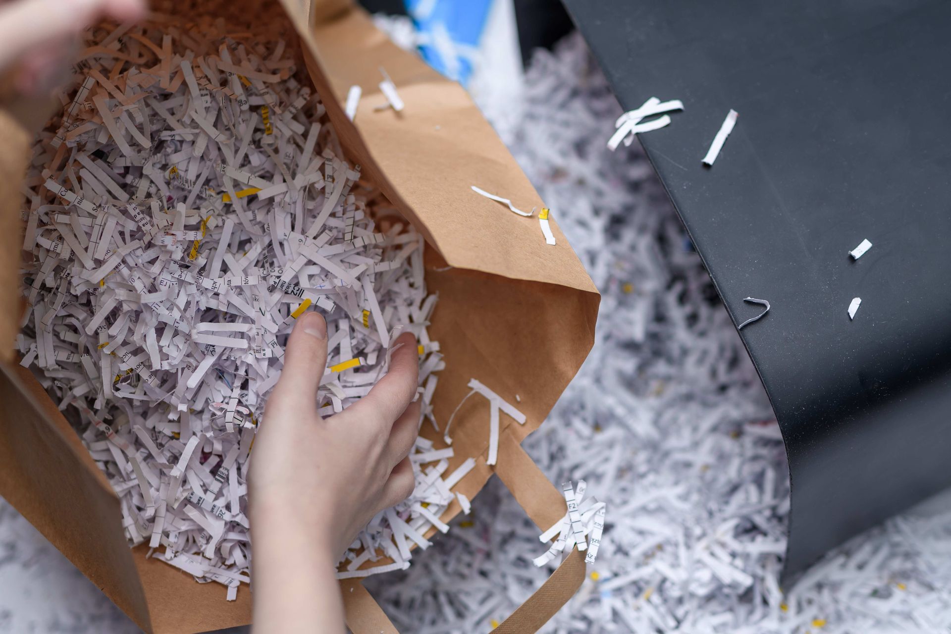 a person is holding a bag of shredded paper