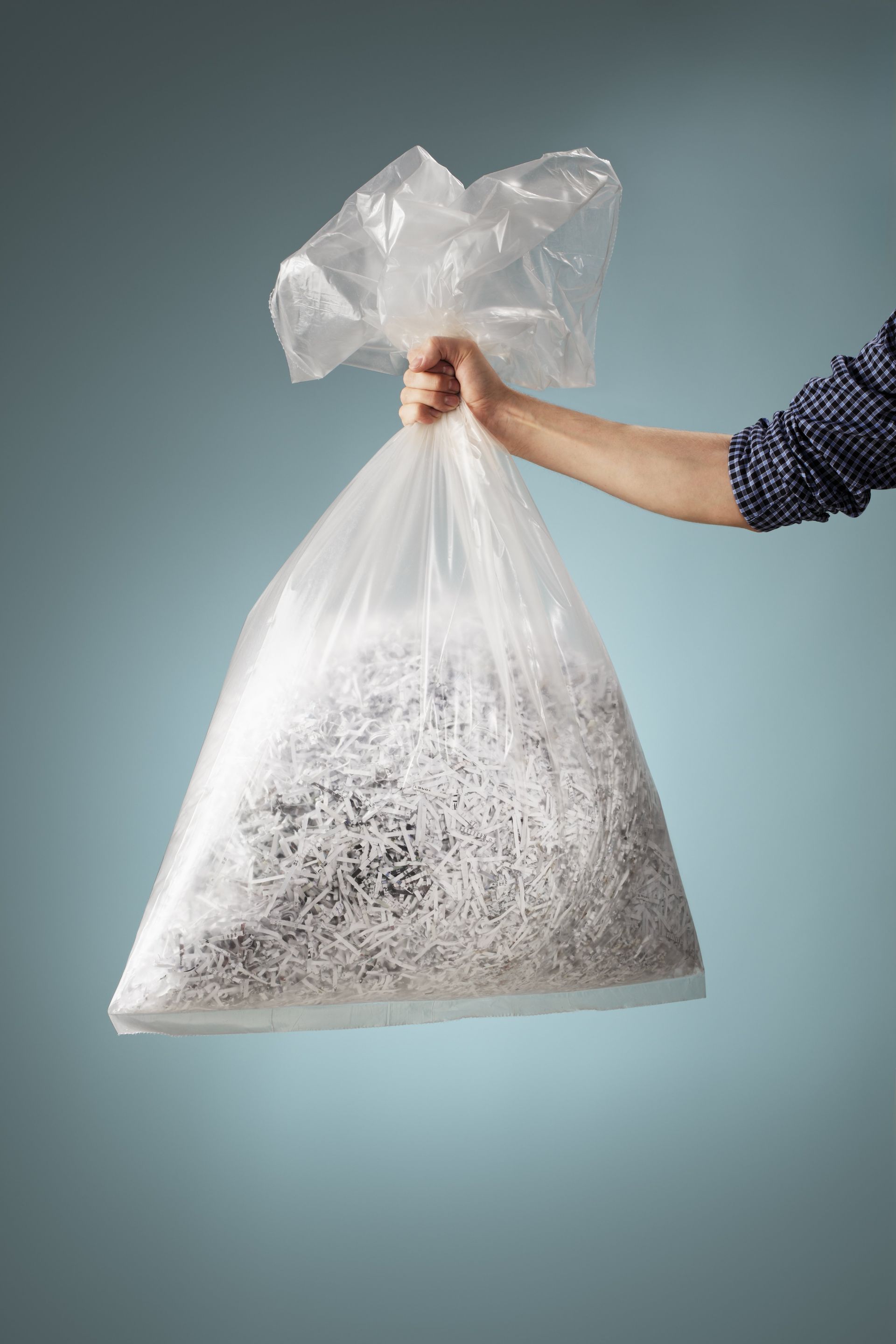 a person is holding a bag of shredded paper