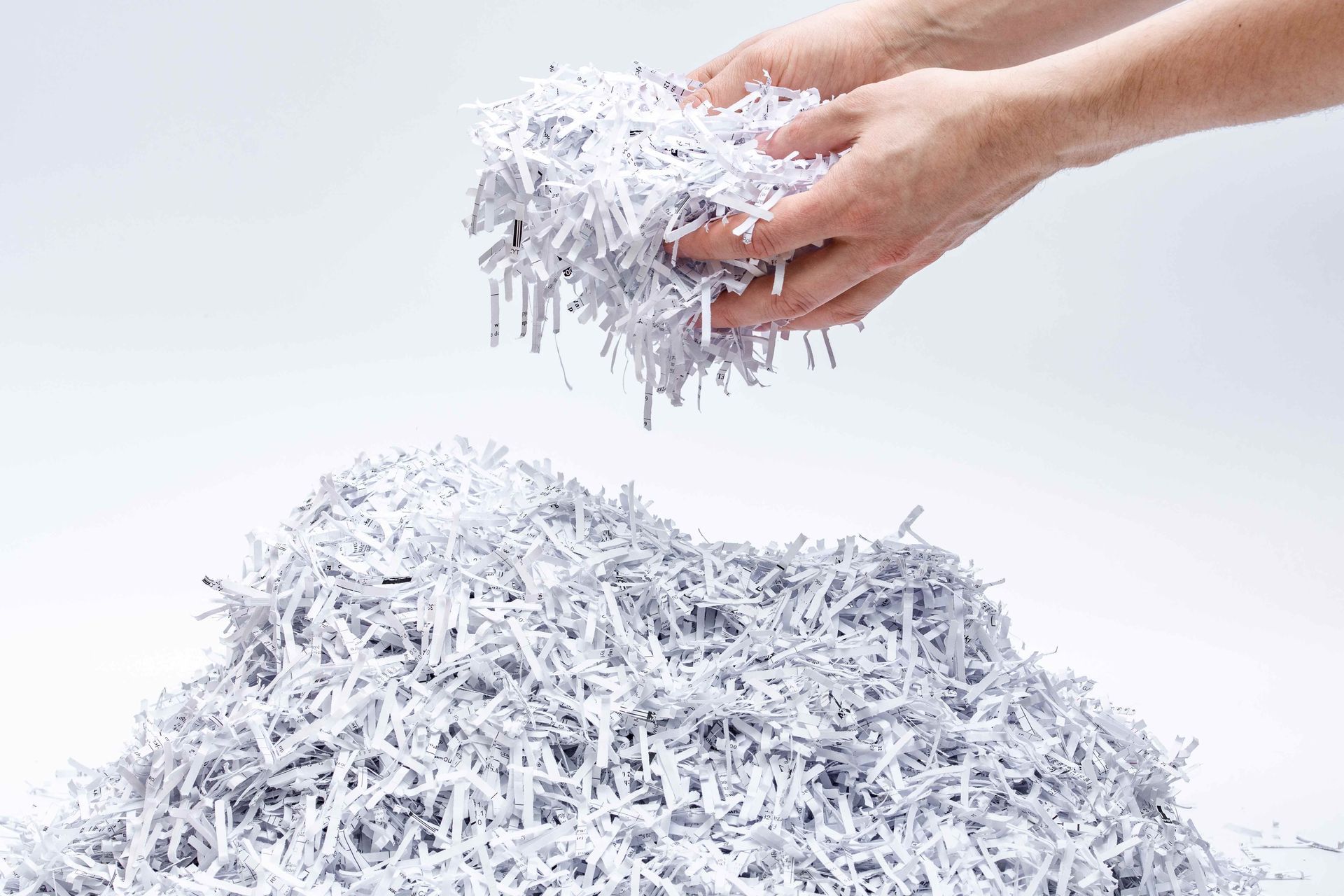 a person is holding a pile of shredded paper in their hands