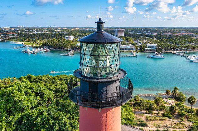 An aerial view of a lighthouse overlooking a body of water.