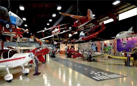 A large hangar filled with lots of small planes hanging from the ceiling.