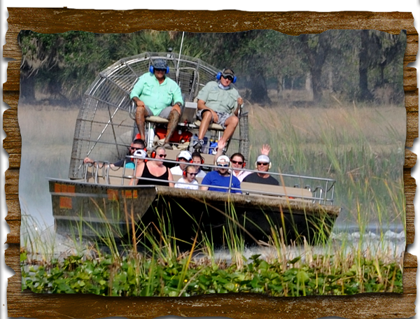 A group of people are riding on a boat in a swamp.