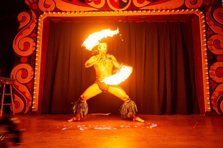 A man is performing a fire show on a stage.