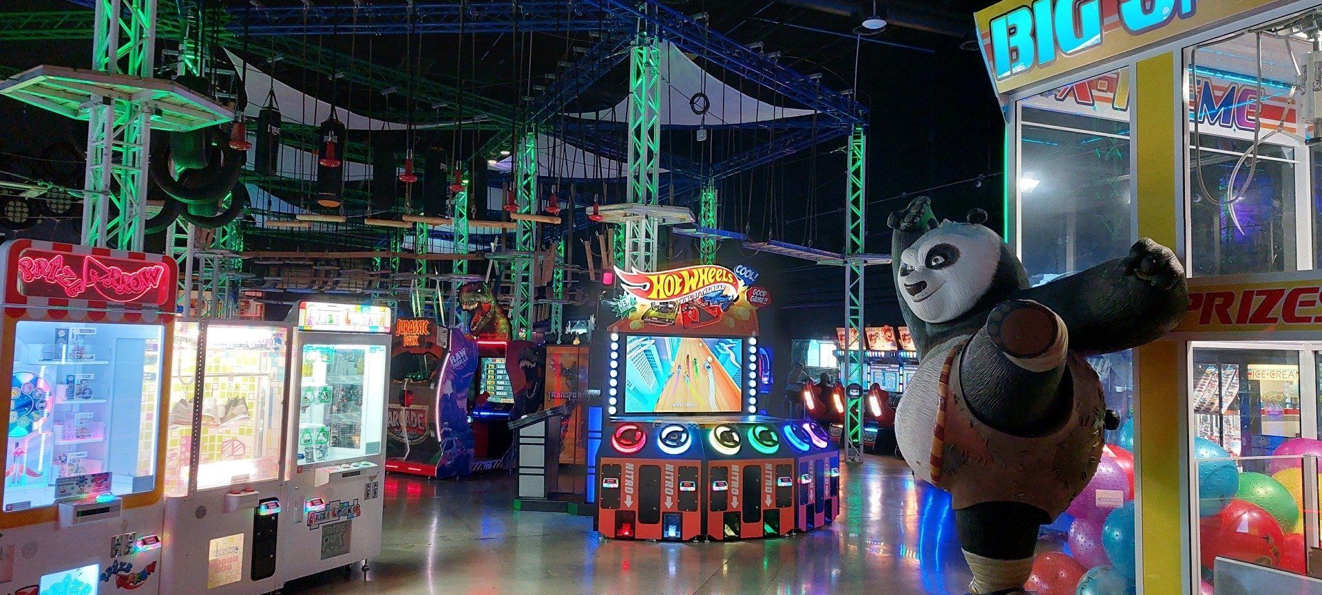 A panda mascot is standing in an amusement park.
