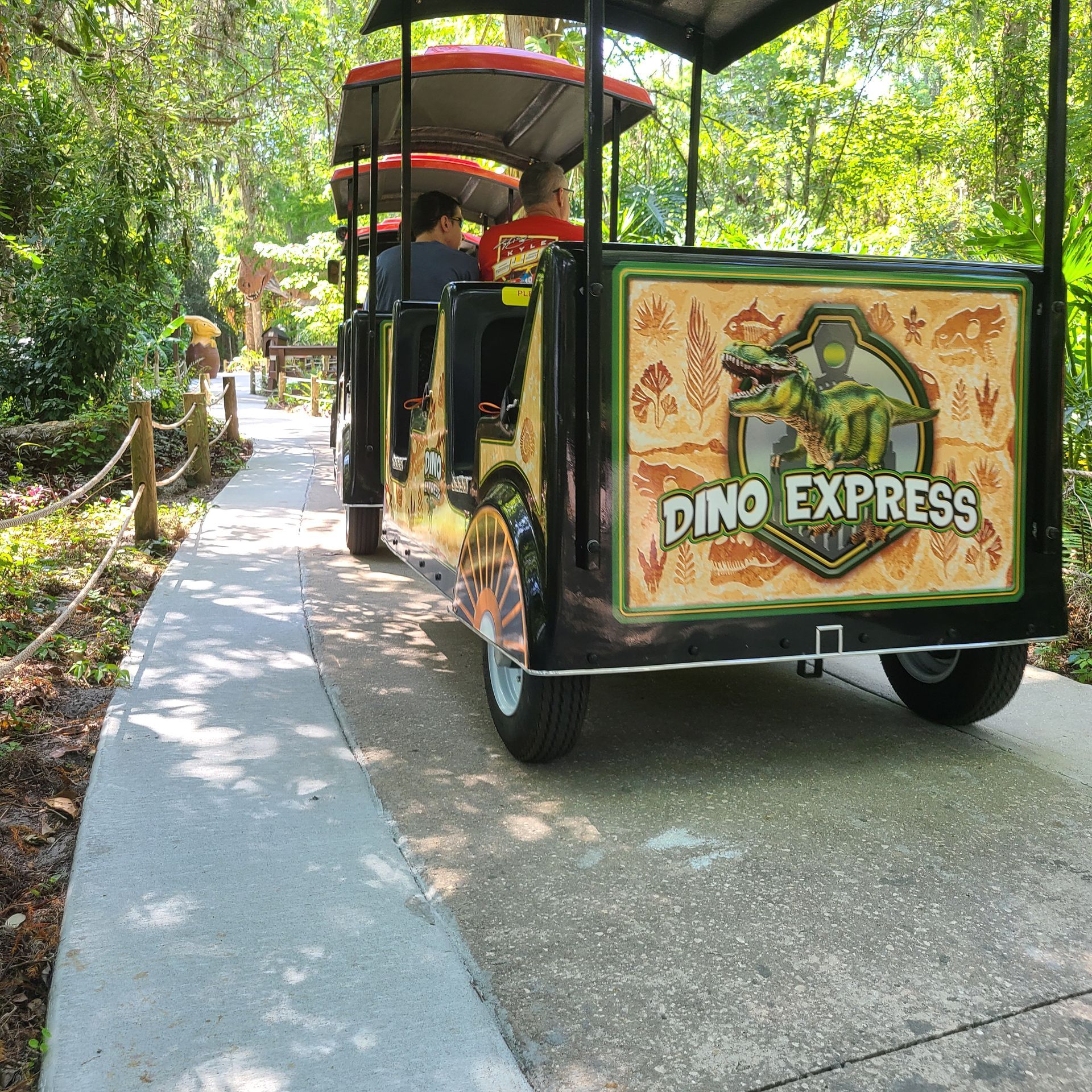 A dino express vehicle is parked on a sidewalk