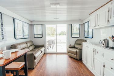 A living room with a couch , chair , table and sliding glass doors.