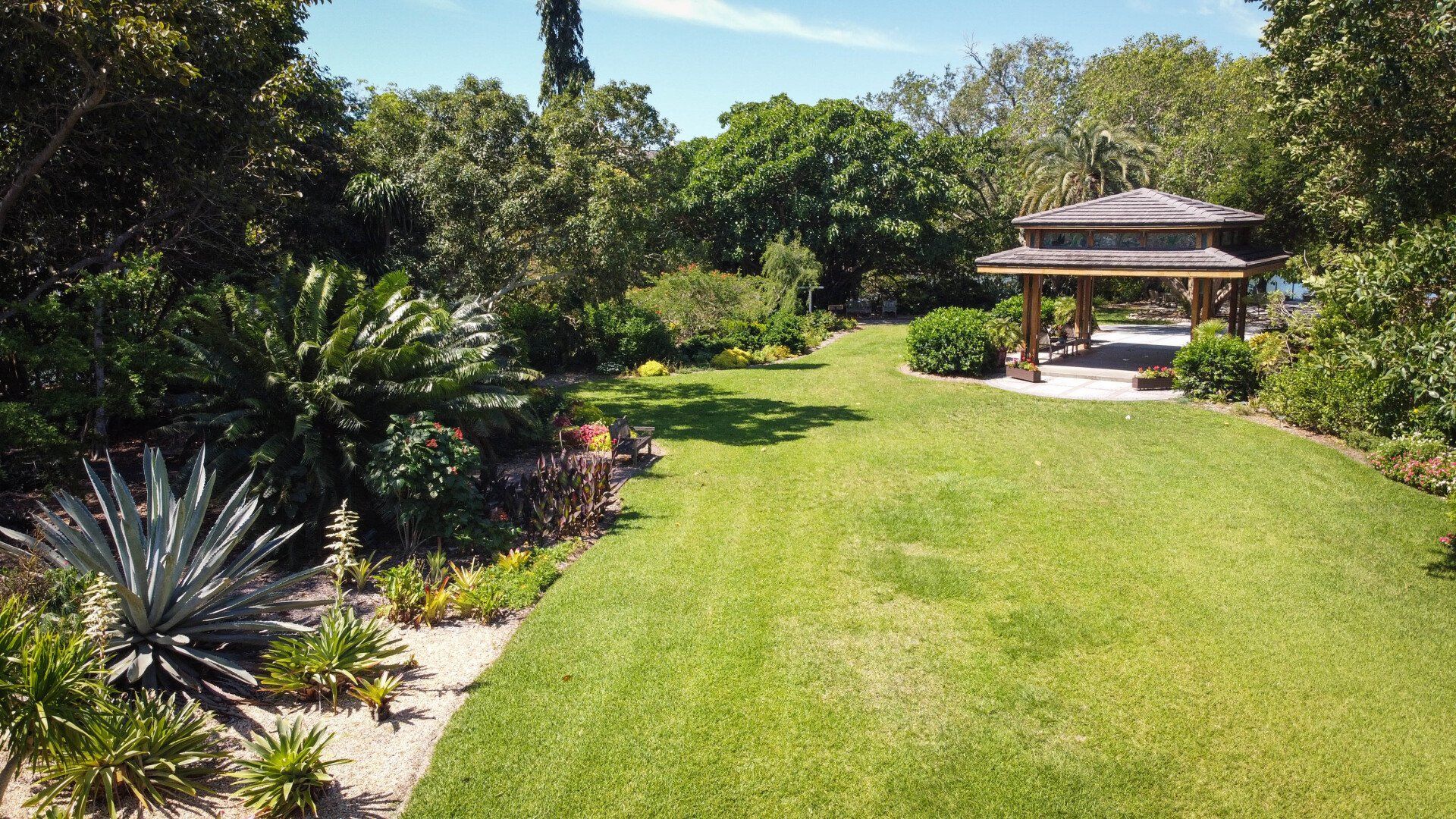 An aerial view of a lush green garden with a gazebo in the middle.