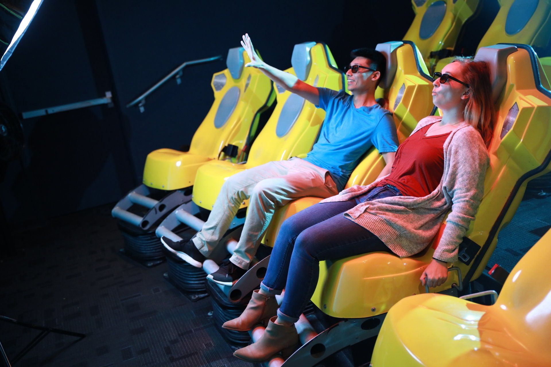 A man and a woman are sitting in yellow chairs watching a movie.