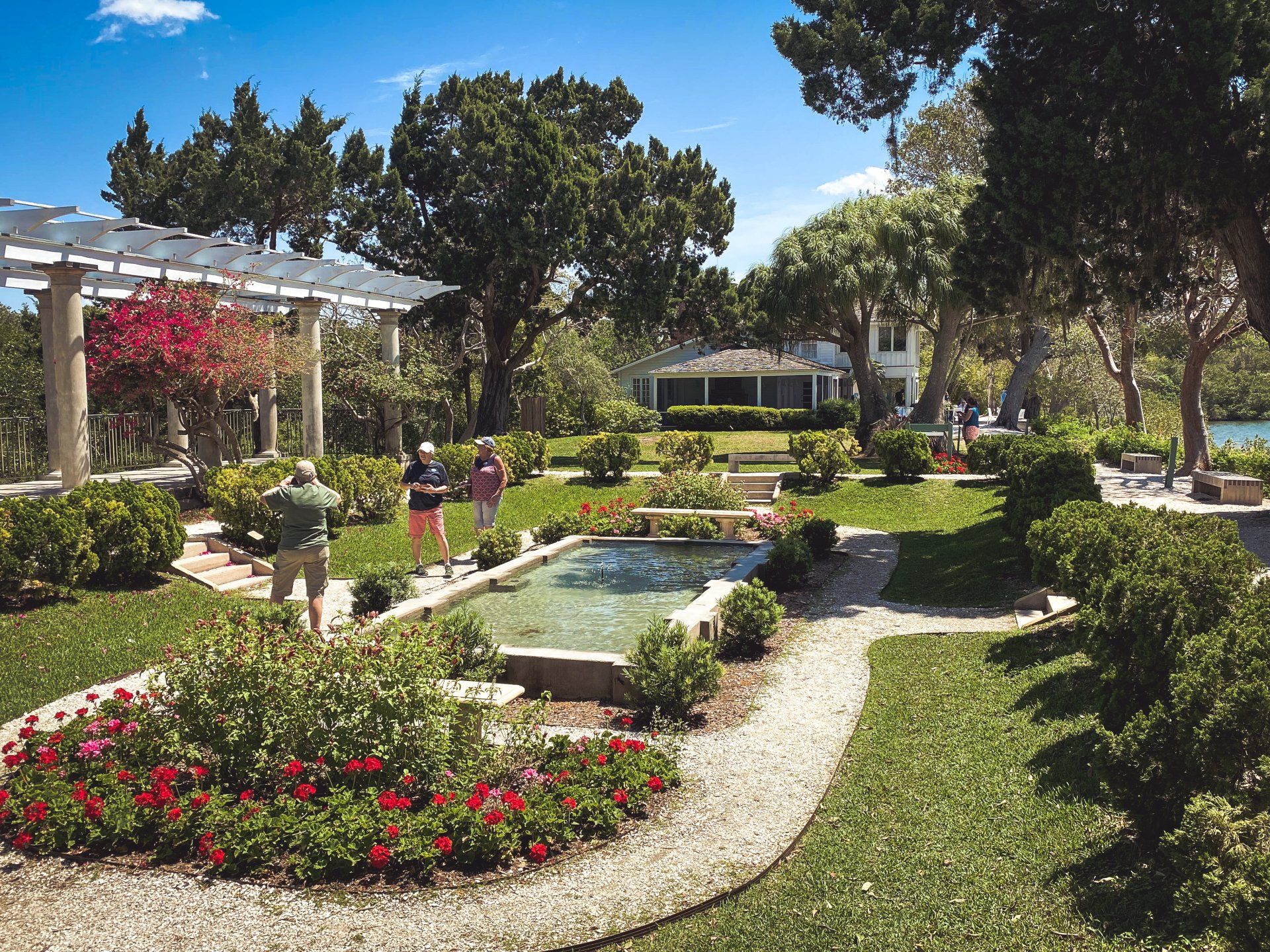 A couple walking in a garden with a fountain in the middle