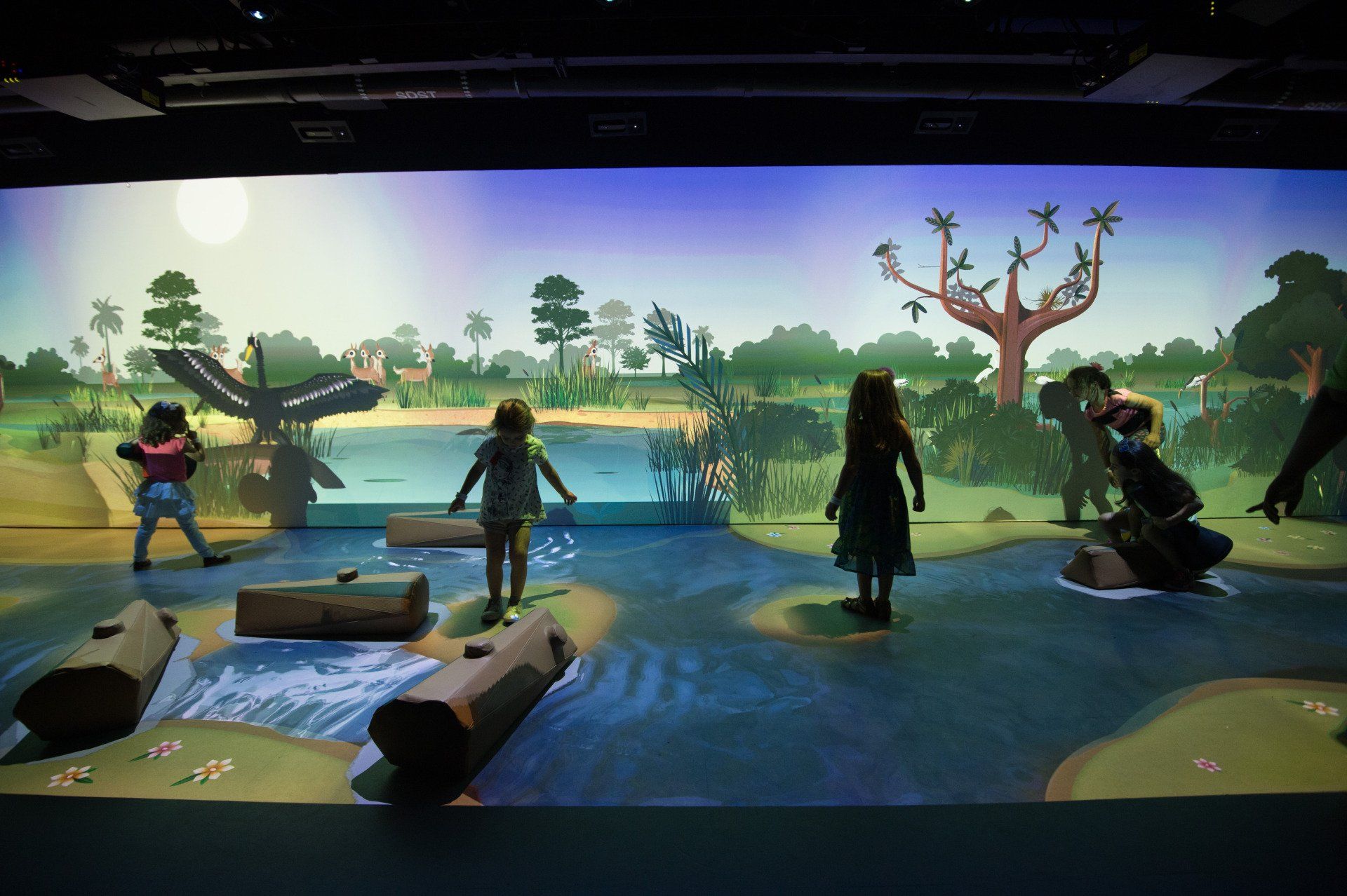 A group of children are playing a video game on a large screen.
