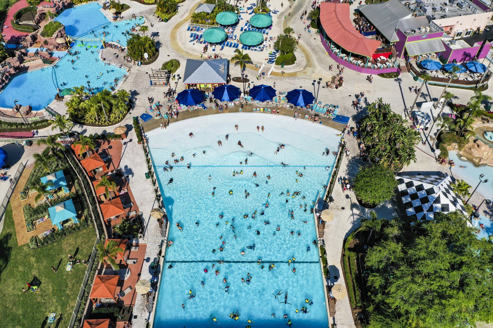 An aerial view of a water park filled with people and swimming pools.
