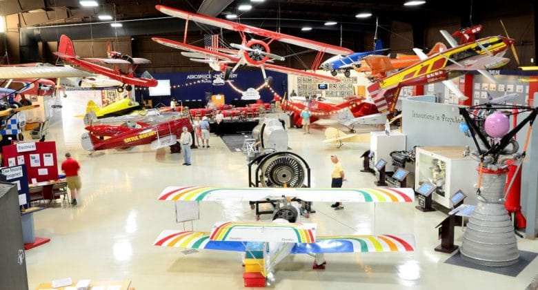 A museum filled with lots of airplanes and people.