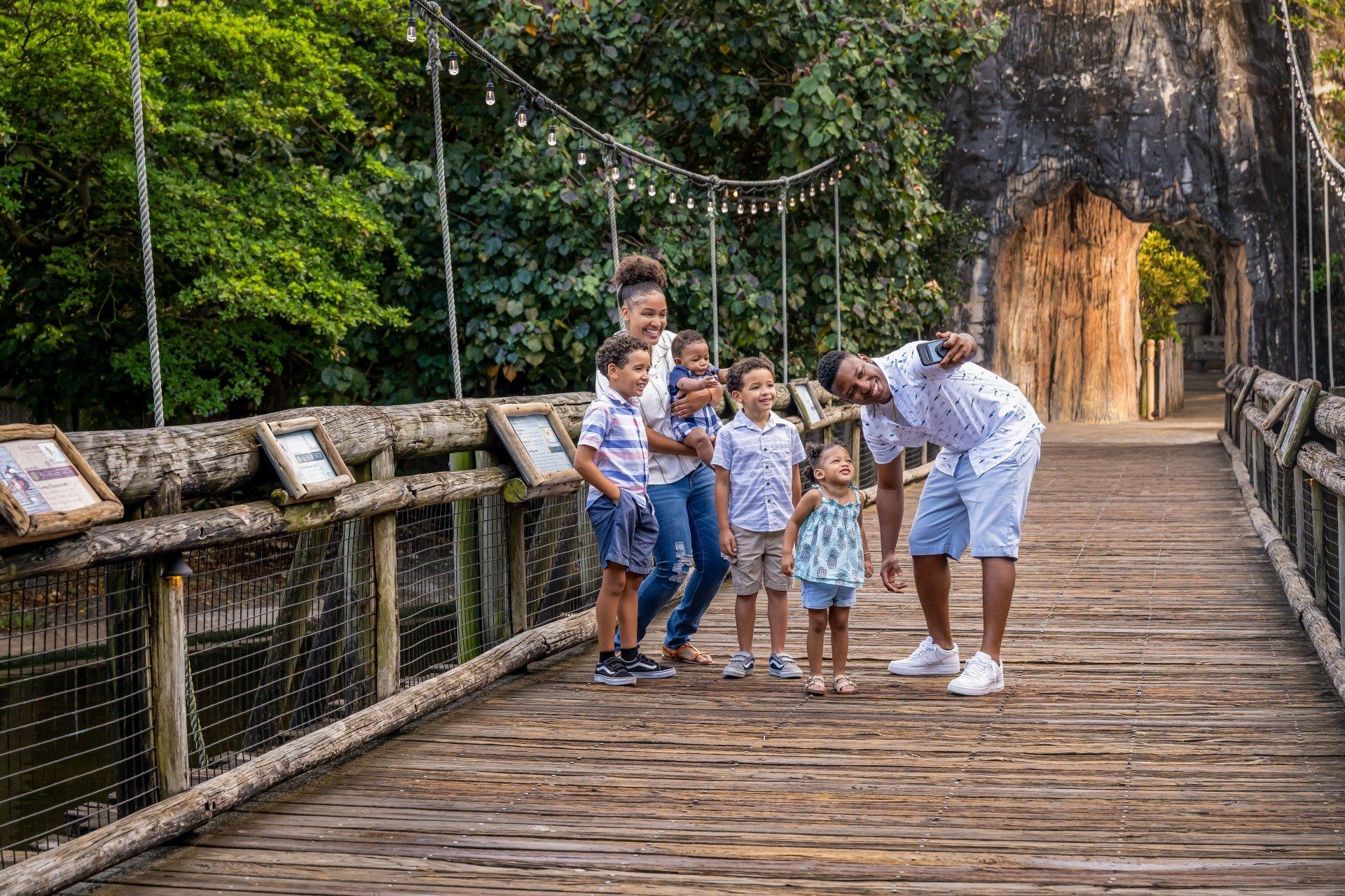 A family is posing for a picture on a wooden bridge.
