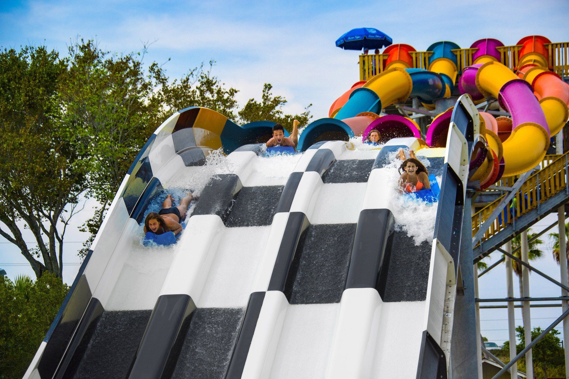 A group of people are riding down a water slide at a water park.