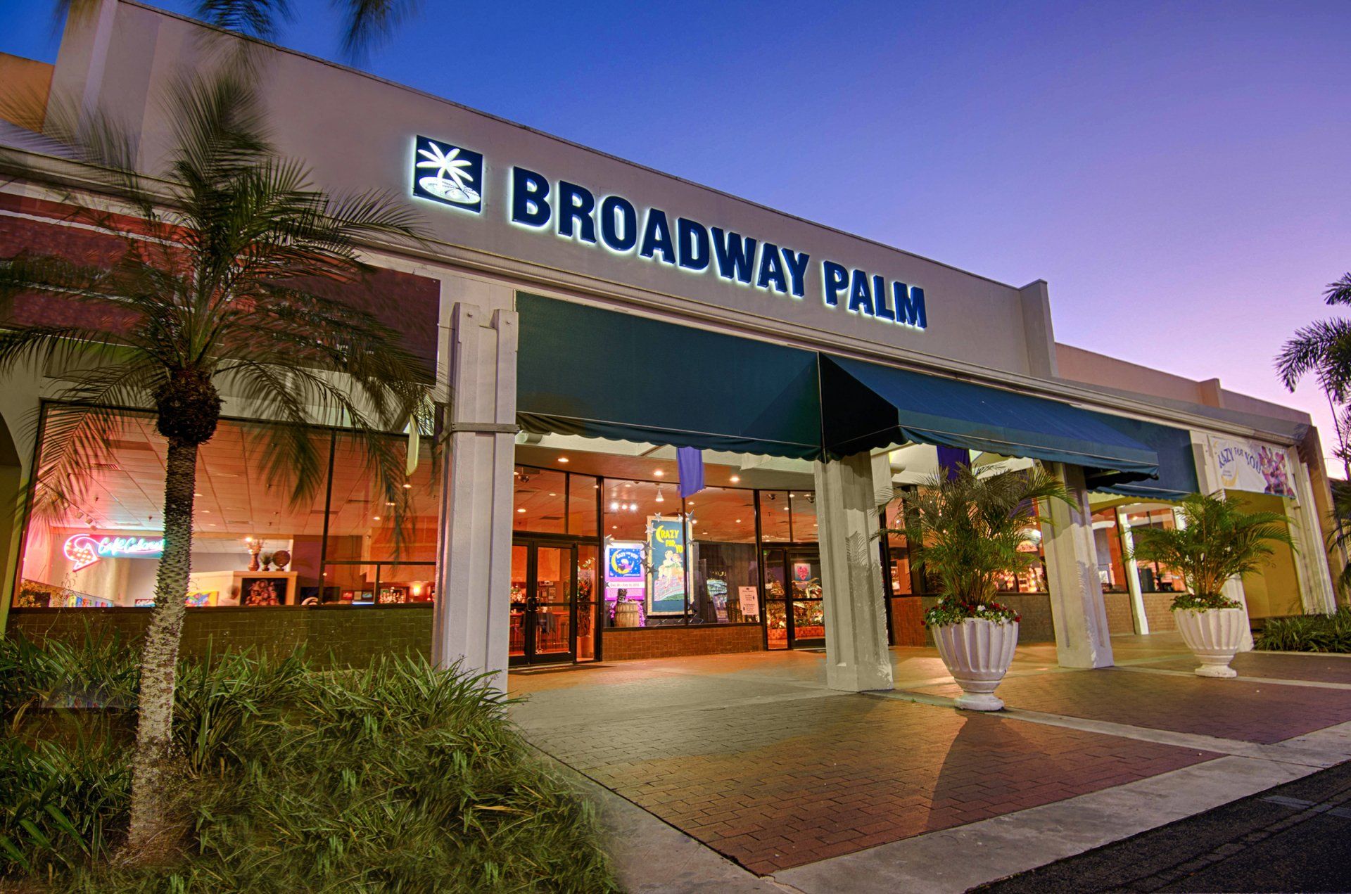 The broadway palm building is lit up at night