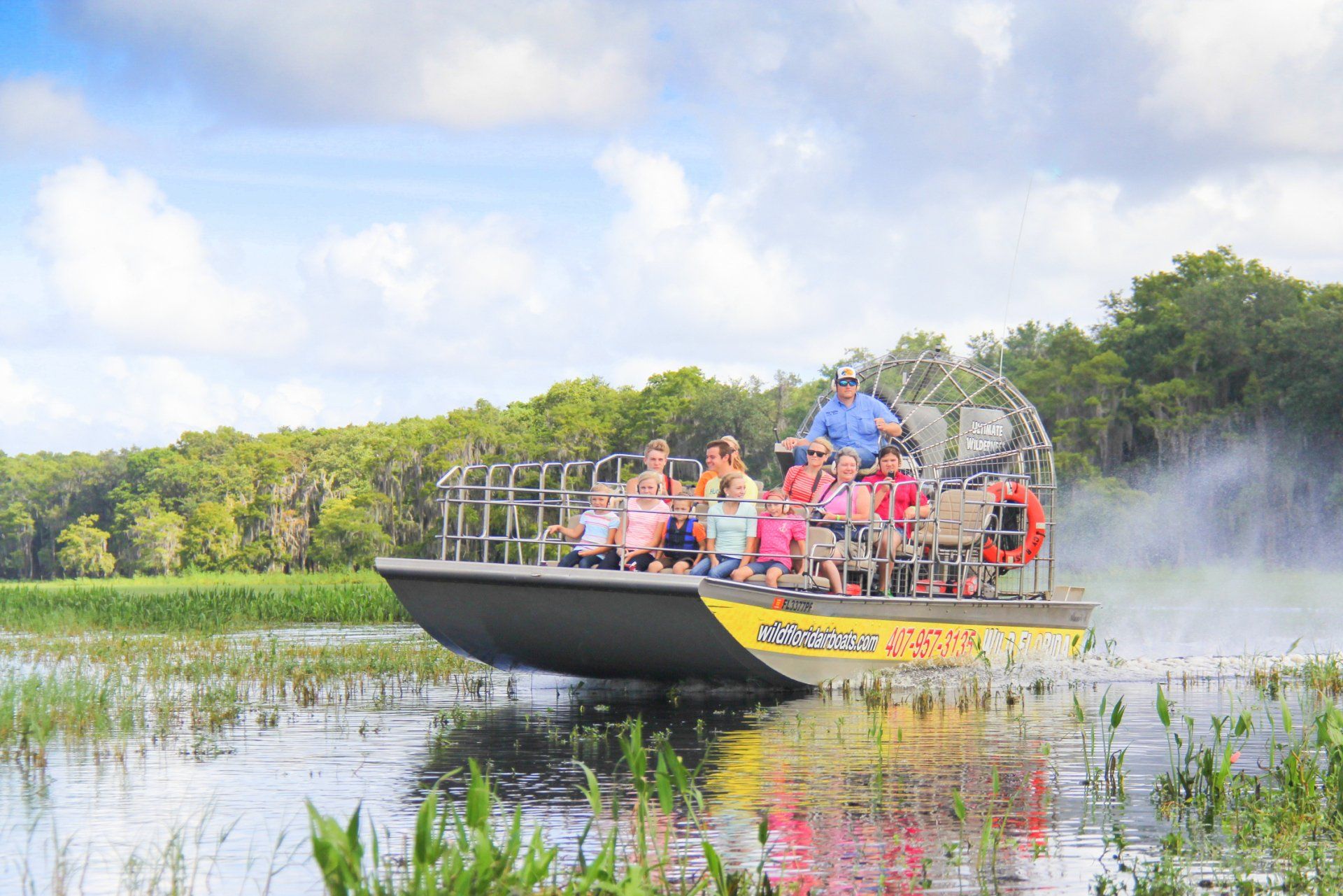 A group of people are riding on a boat in a swamp.