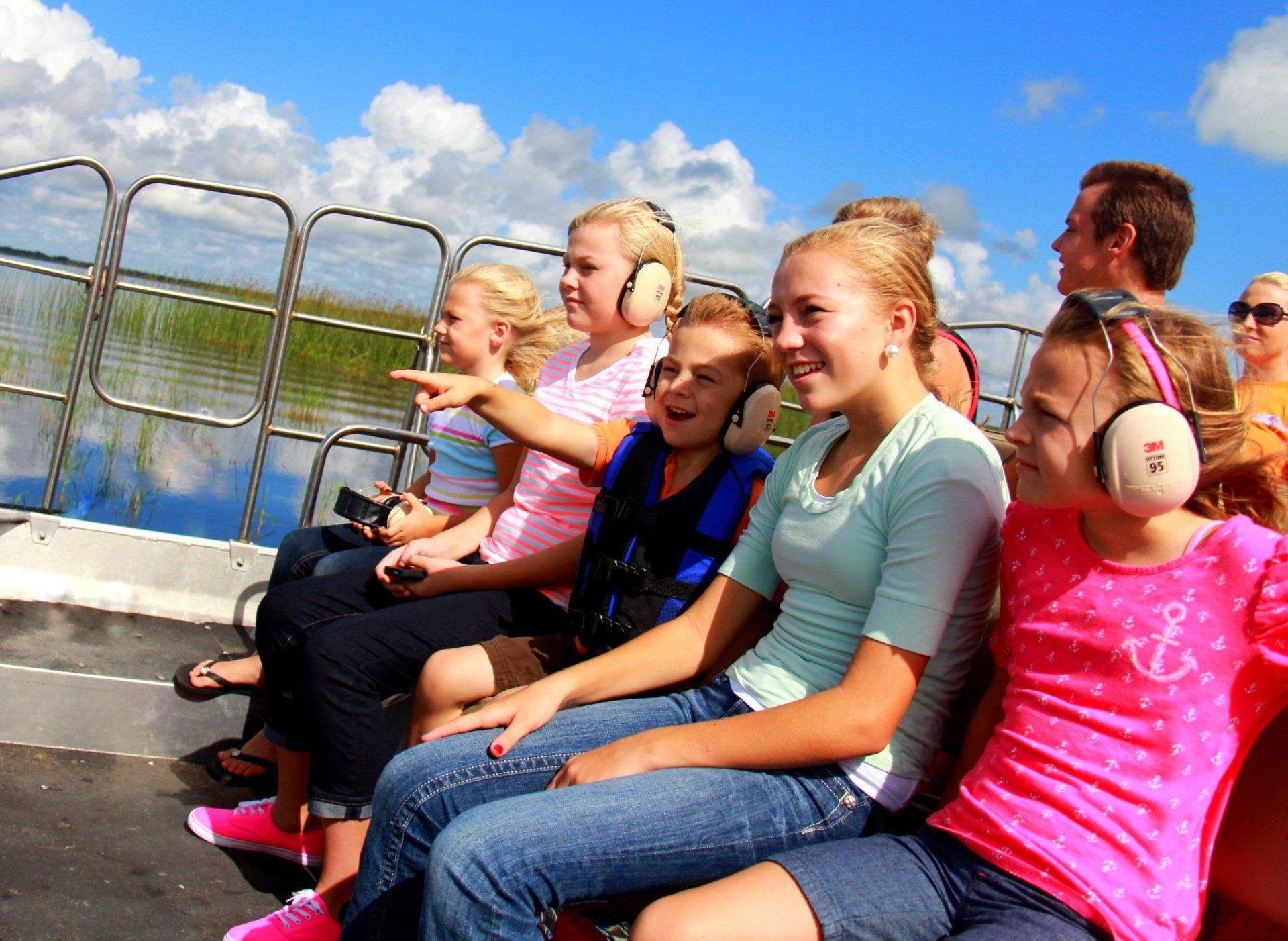 A group of people wearing headphones are sitting on a boat.