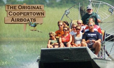 A group of people are riding a coopertown airboat