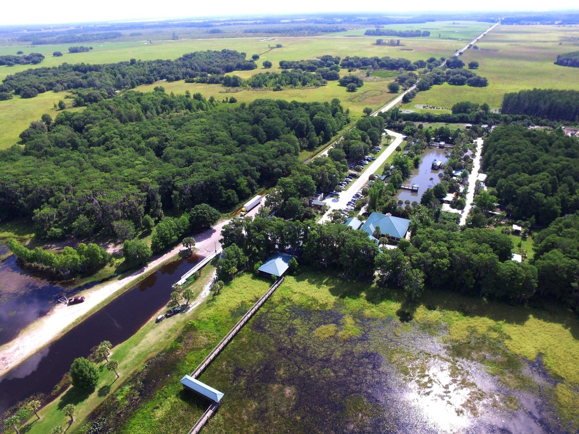 An aerial view of a lake surrounded by trees and grass