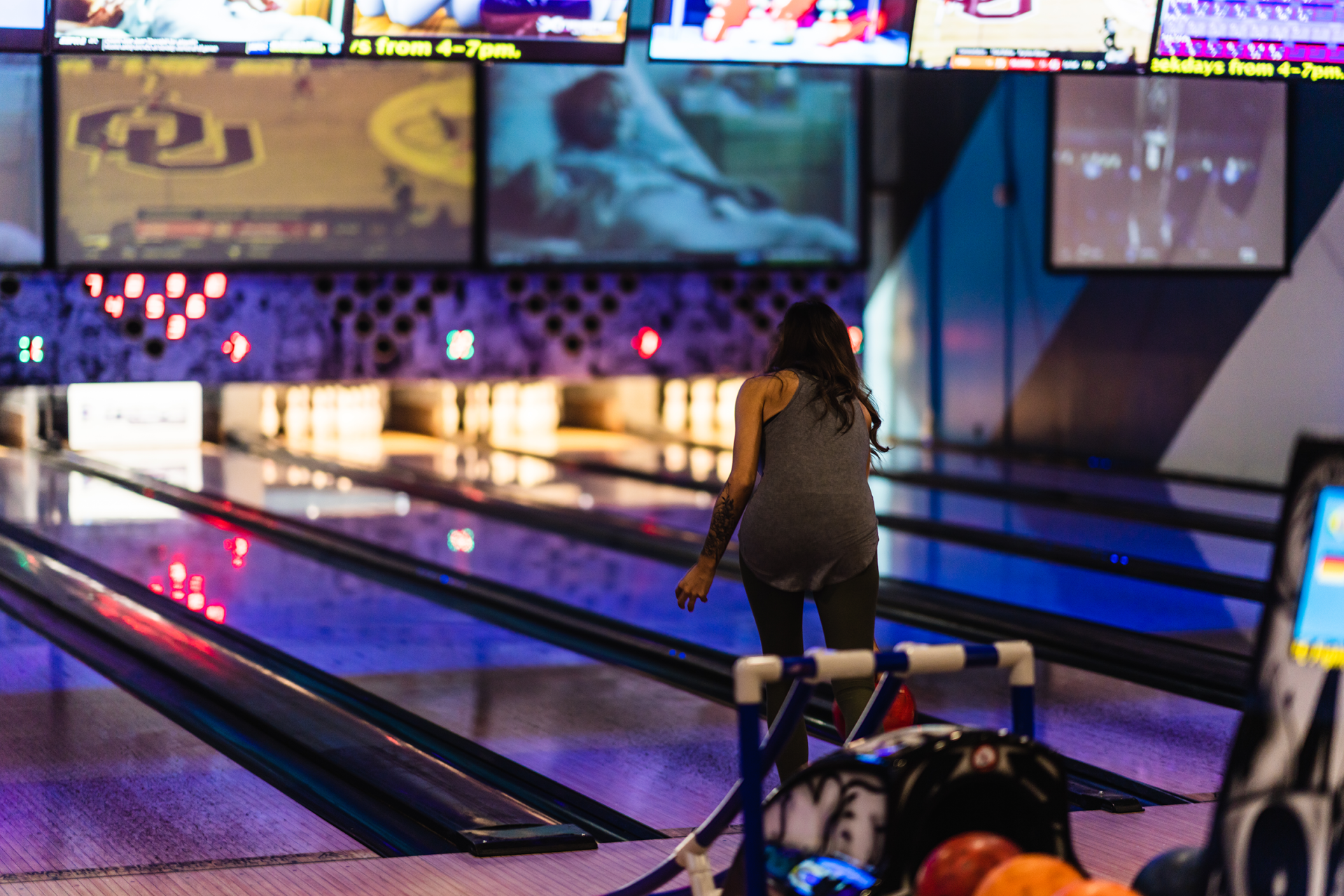 A woman is playing bowling in a bowling alley.