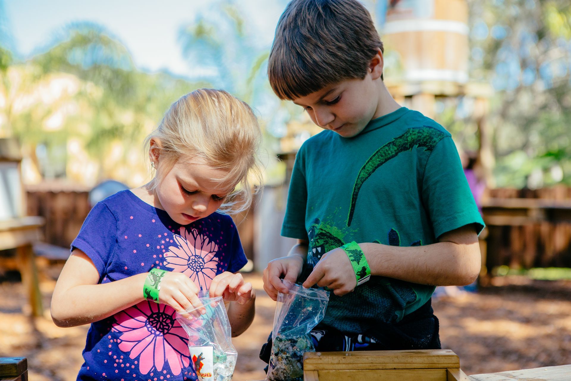 A boy and a girl are playing with a bag of rocks.