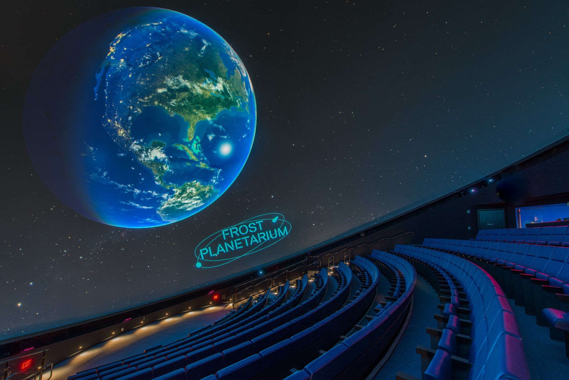 A planetarium with a picture of the earth projected on the wall.