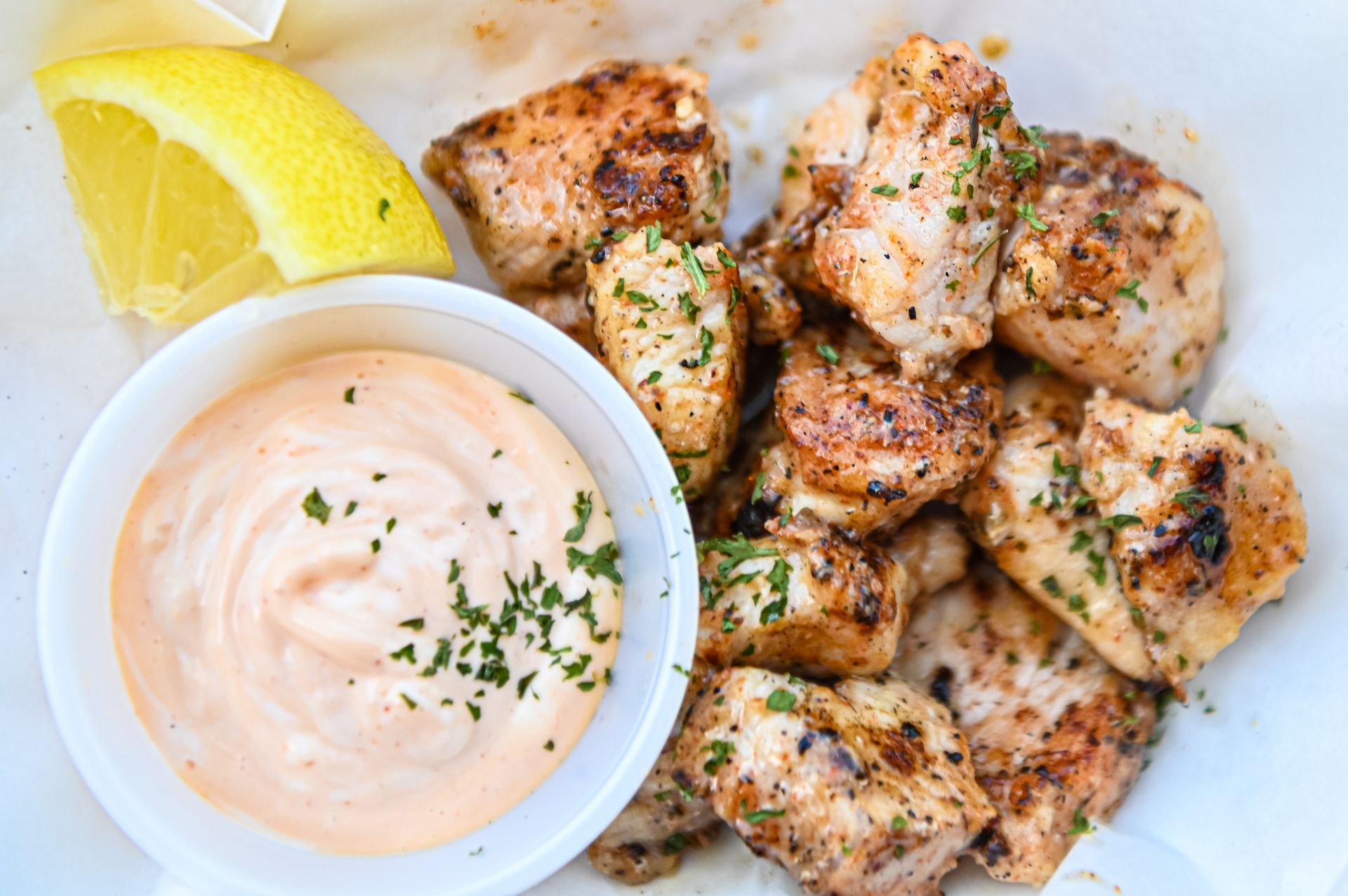 A white plate topped with chicken nuggets and a bowl of dipping sauce.