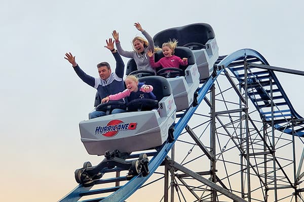 A family is riding a roller coaster at an amusement park.