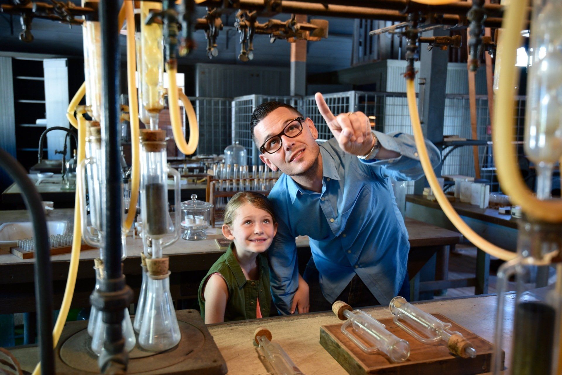 A man and a little girl are posing for a picture in a lab.