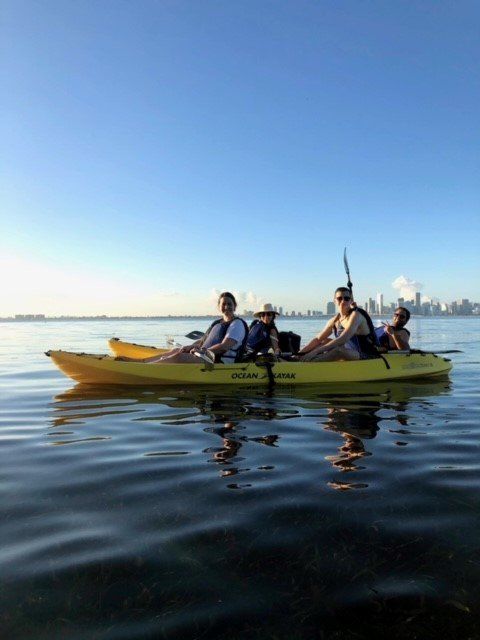 A group of people are in a yellow kayak on a lake