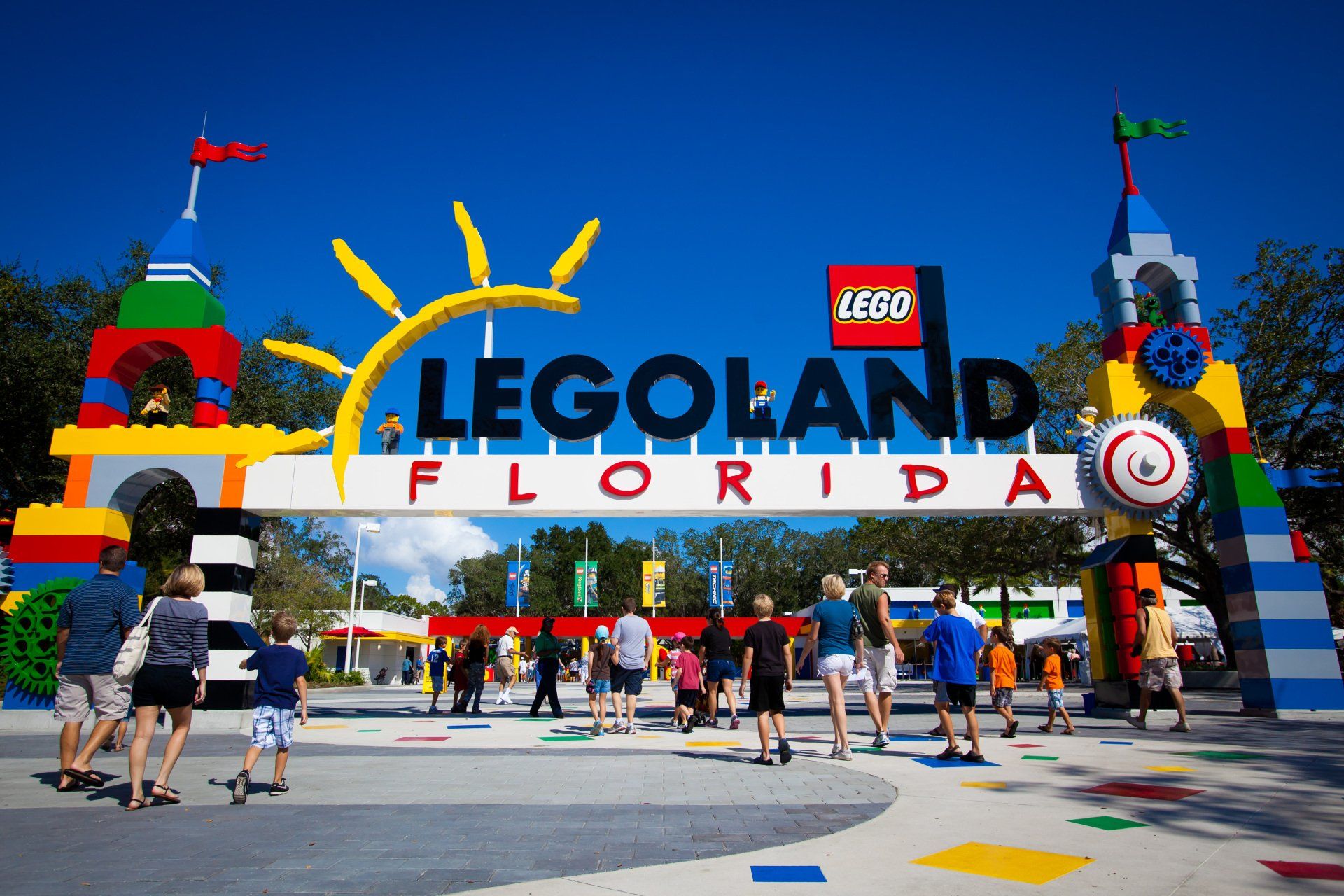 A group of people are standing under a sign that says legoland florida