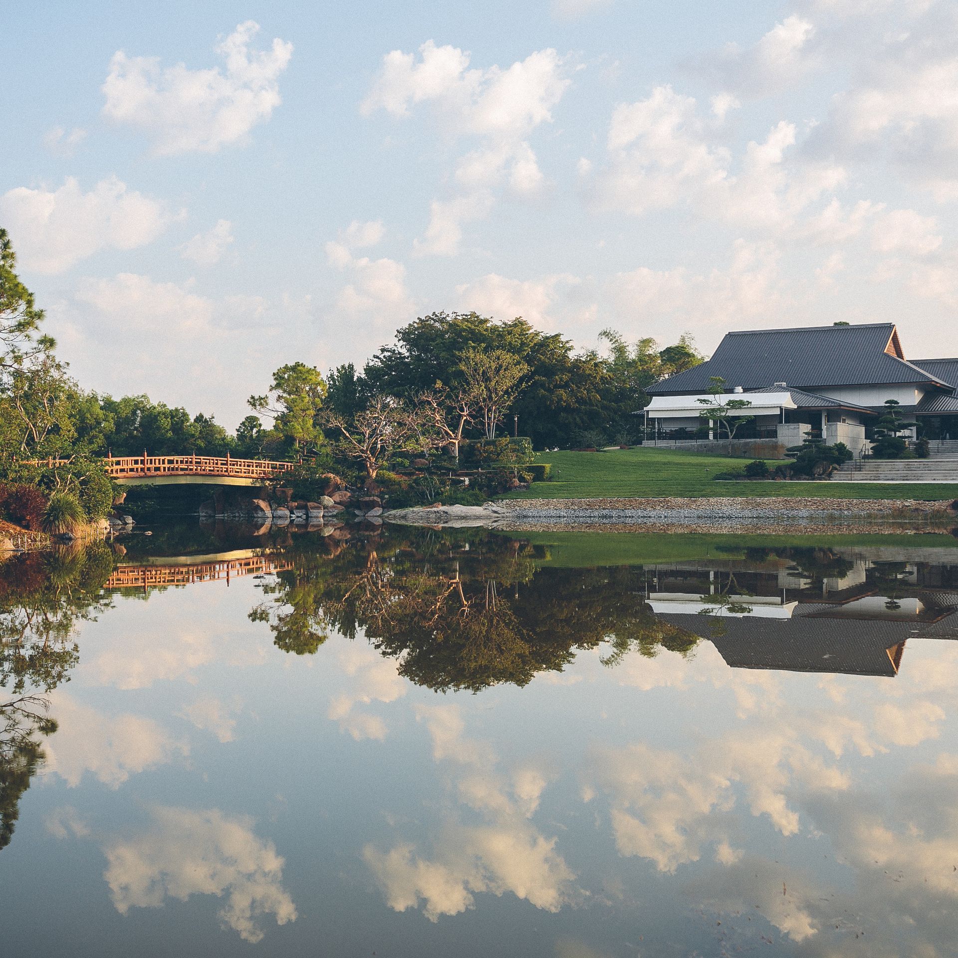 A bridge over a body of water with a house in the background
