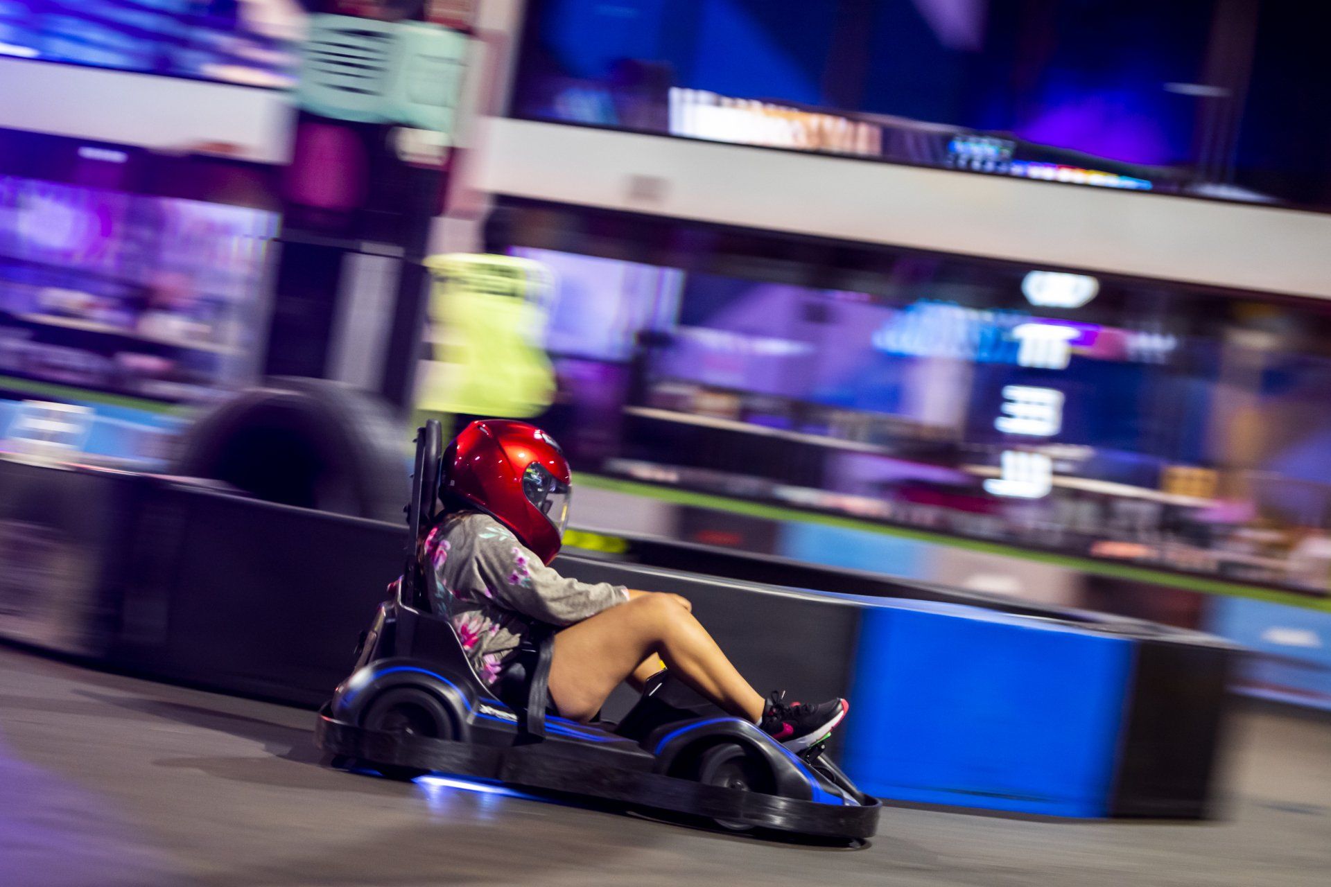 A woman is riding a go kart on a track.