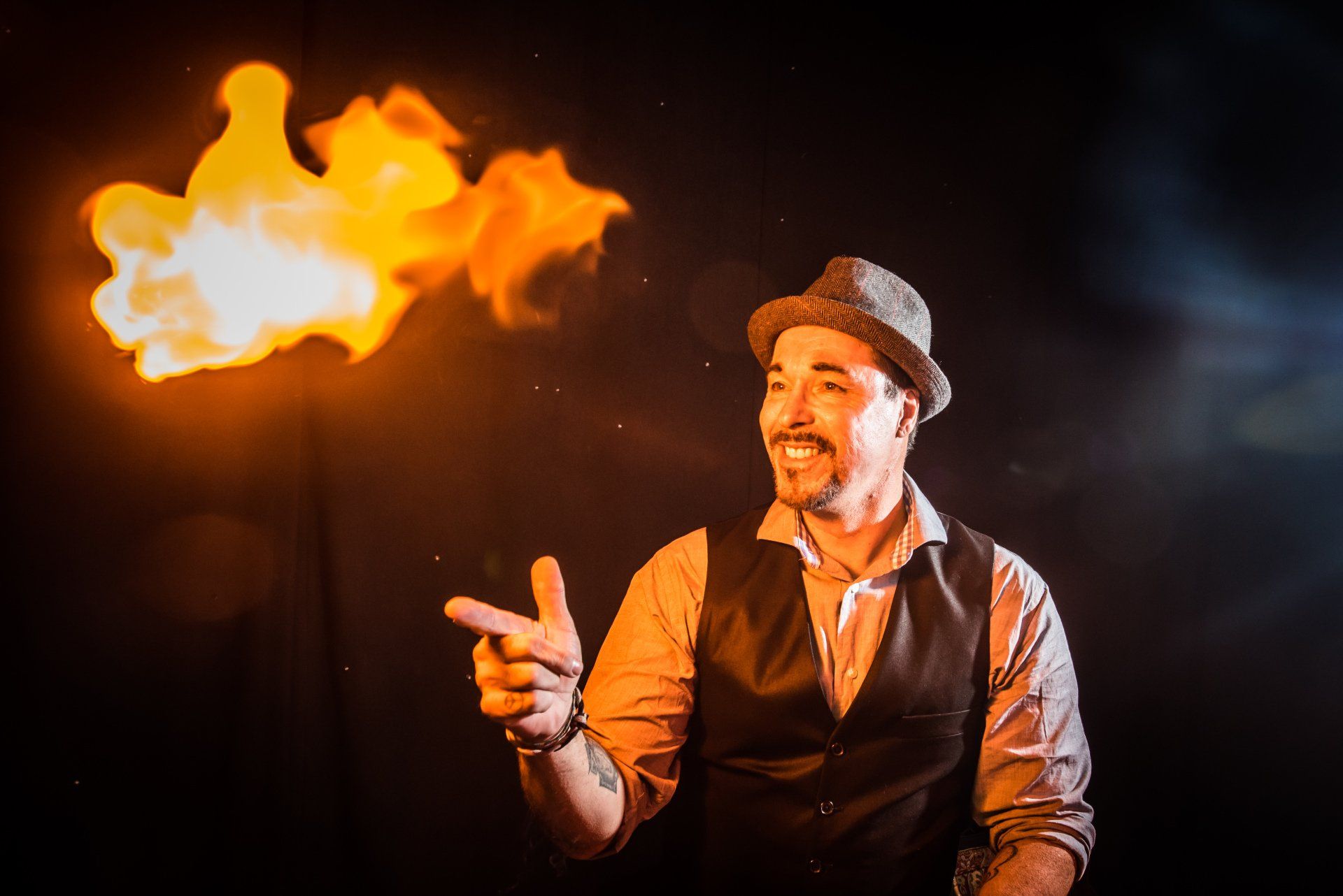 A man in a hat is holding a fireball and pointing at it.