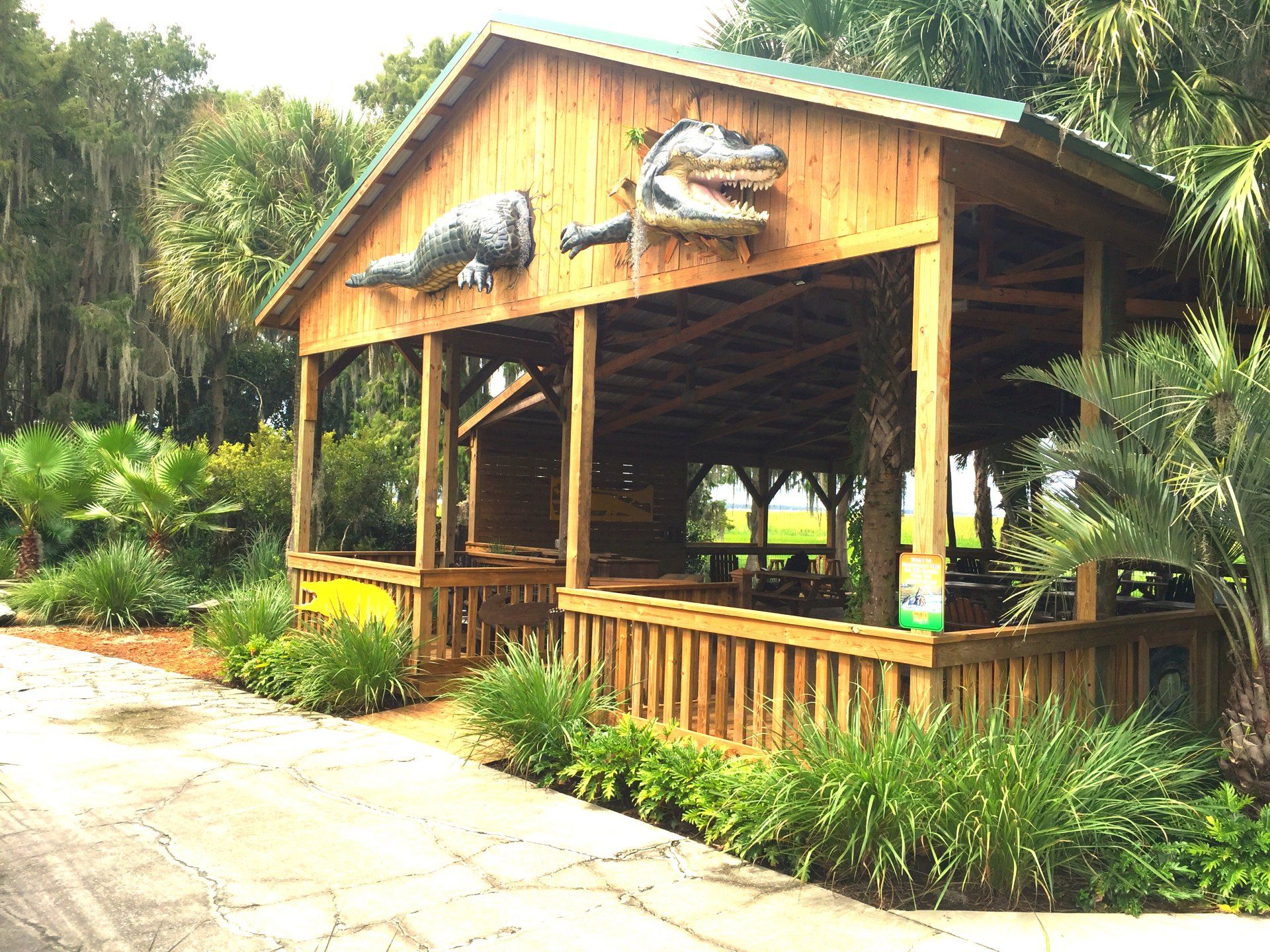 A wooden pavilion with two alligators on the roof