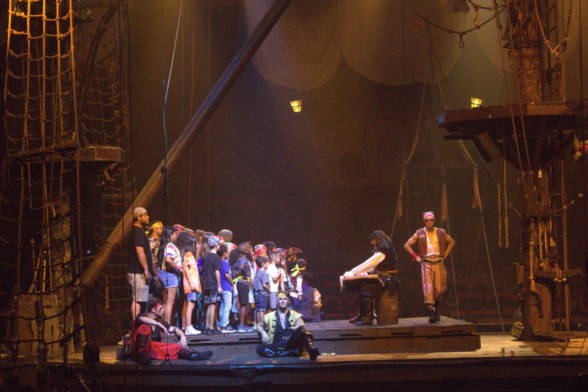 A group of people are standing on a stage in a dark room