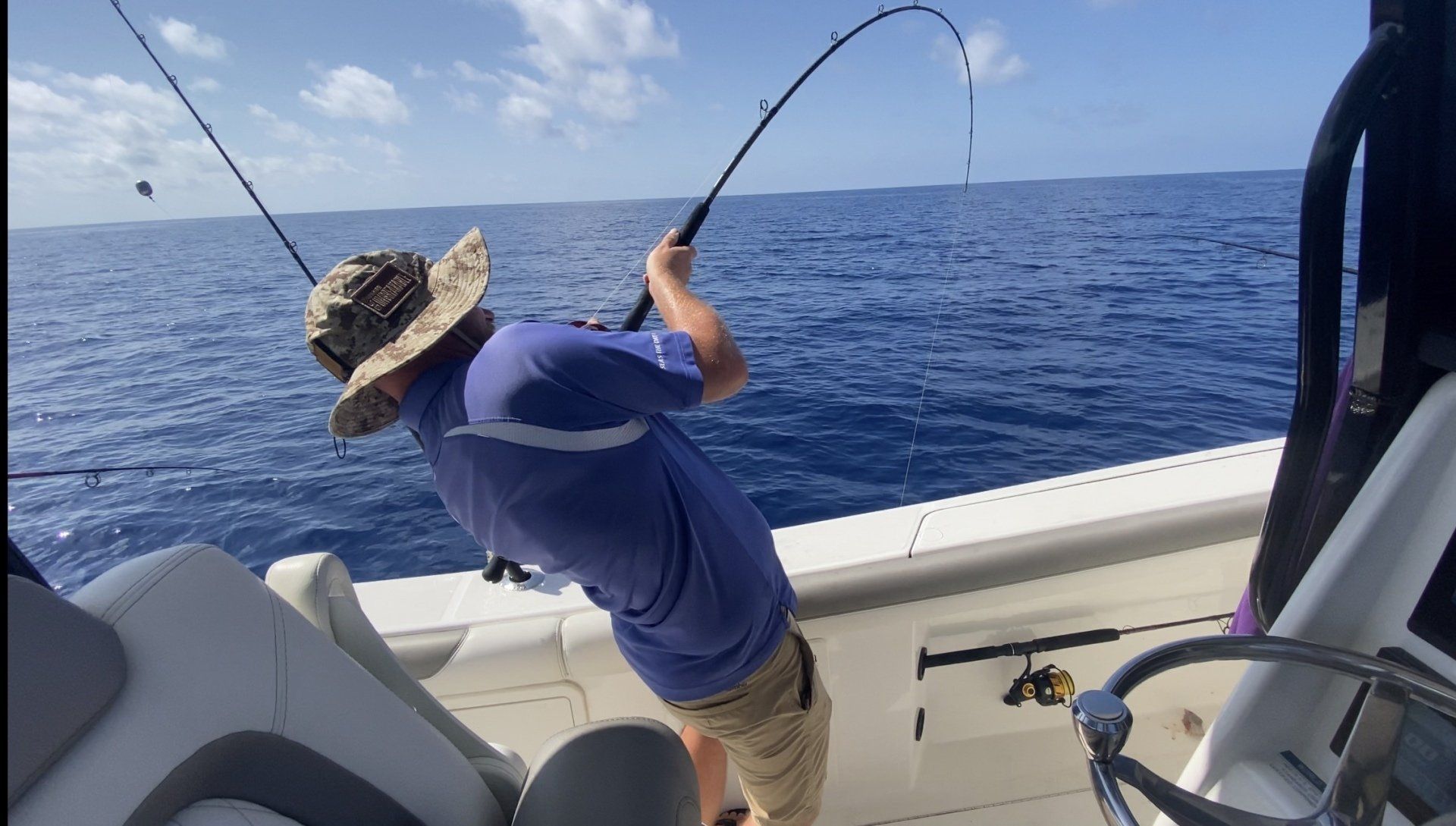 A man is fishing on a boat in the ocean