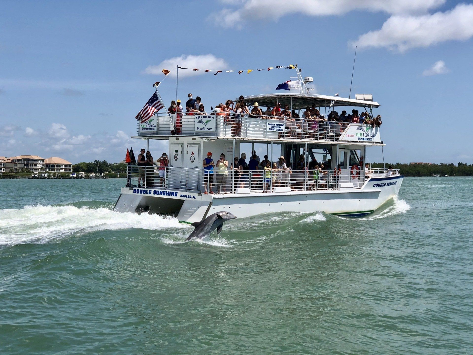A boat filled with people is floating on top of a body of water.