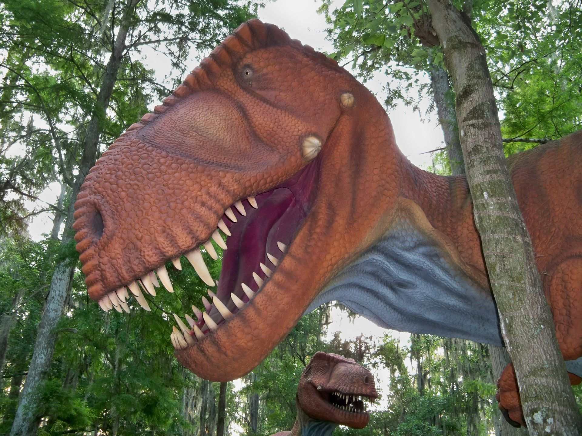 A statue of a dinosaur with its mouth open